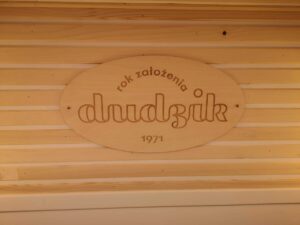 Wycinka napisów w płycie z drewna - logo naniesione na tabliczkę z drewna.