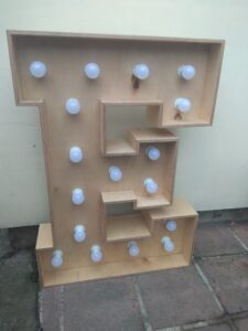 Litera przestrzenna z żarówkami - litera E z napisu LOVE na wesele dla pary młodej oraz dekoratorów.