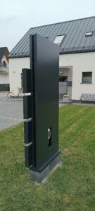 Tył wolno stojącego pylonu reklamowego zlokalizowany przed budynkiem.